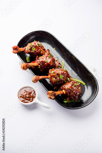 Szechuan Chicken which is a popular Indo-Chinese non vegetarian recipe. served in a plate with chilli sauce. selective focus