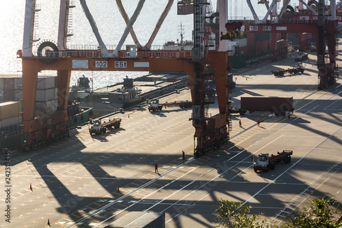 Industrial port crane lift up loading export containers box onboard from truck at port of Thailand,The port crane type's twinlift is the best solution for port operations. photo