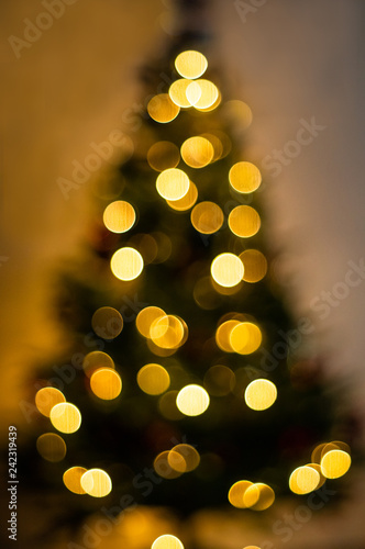 Bokeh silhouette of Christmas tree. Abstract christmas background with defocused lights