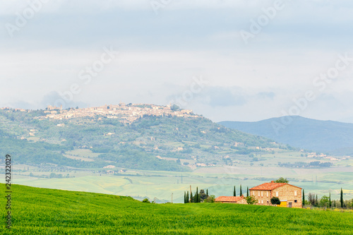Farm on a field with a village on a hill in Italy
