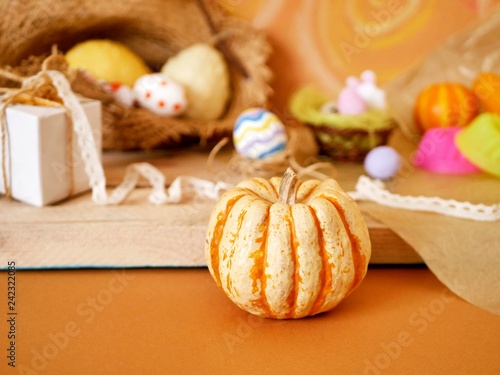 Easter decoration, painted eggs, yellow vegetables, pumpkins on a wooden light table, homemade holiday preparation concept, rustic life