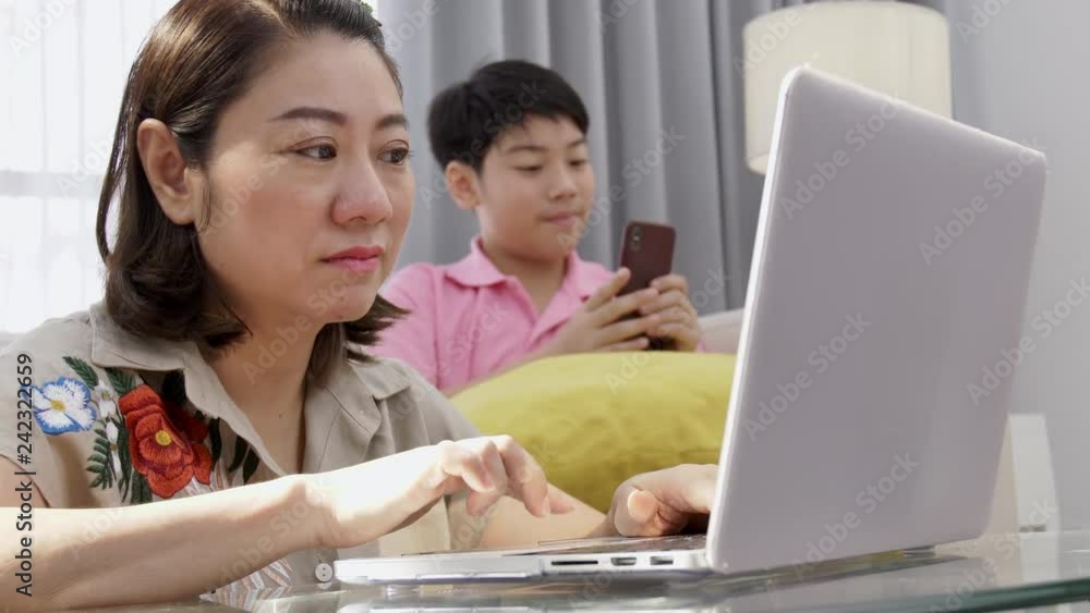 4K Family lifestyle is playing computer games. Asian Mother and son watching on laptop computer with smile face. 4K Family lifestyle is playing computer games. Asian Mother and son watching on laptop computer with smile face.