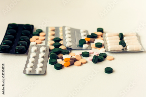 Medicine green  pink and yellow pills or capsules on white background with copy space. Drug prescription for treatment medication. Blister pack.