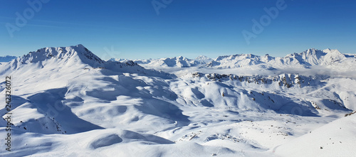 beautiful view on alpine french snowy peak mountain under blue sky © coco