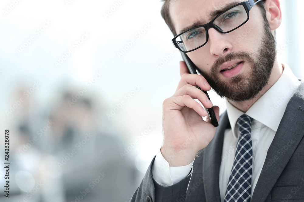 businessman talking on smartphone on office background businessman talking on smartphone on office background