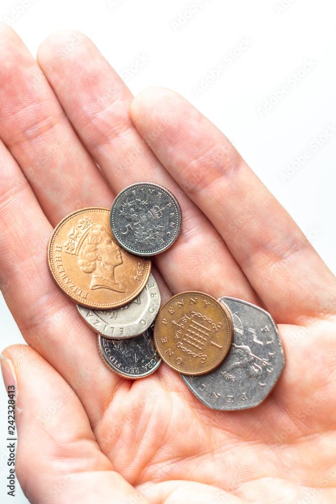 Hand holding a collection of British UK coins. Isolated on the white background. Hand holding a collection of British UK coins. Isolated on the white background.