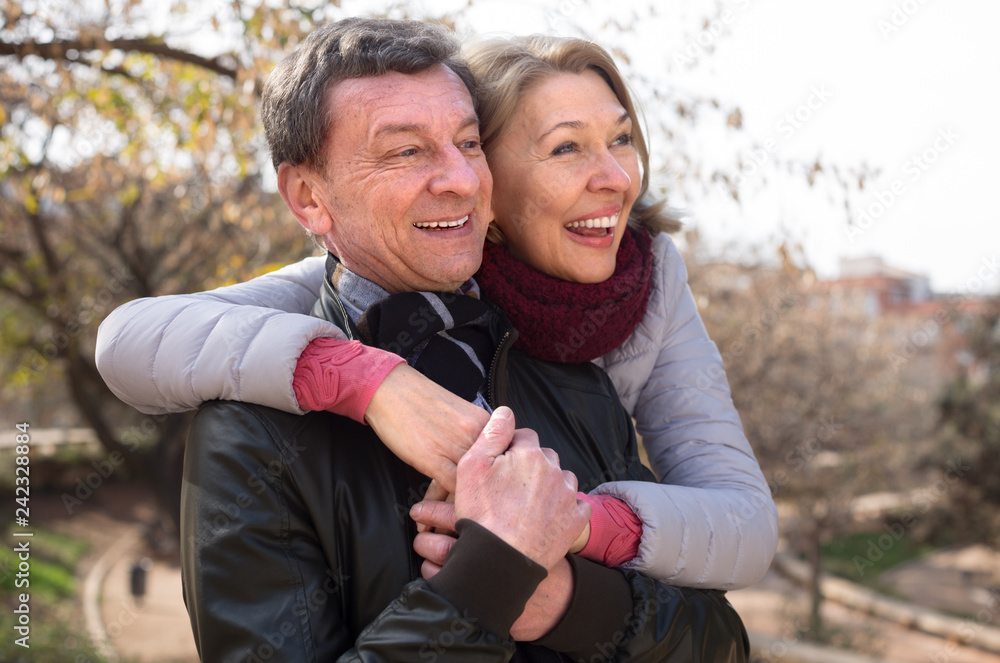Fototapeta premium senior man and mature woman together against blured trees of park