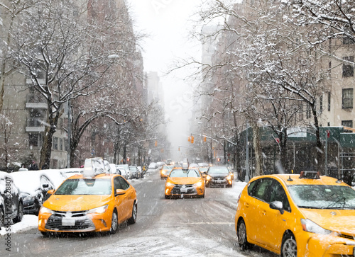 New York City taxis drive down Fifth Avenue through the snow during a winter blizzard in Manhattan