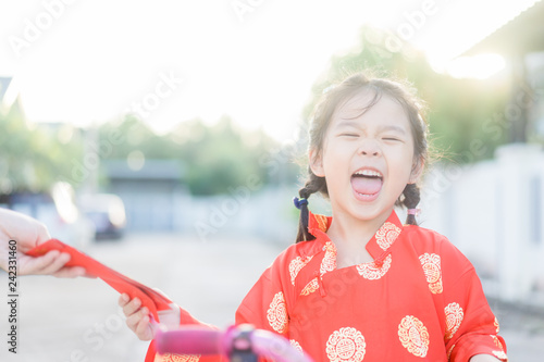 4 years old asian chinese child girl receive money from her mother.Happy Little asian girl in chinese traditional dress smiling and holding red envelope.Happy chinese new year concept.