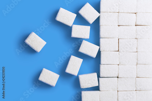 White sugar cubes, isolated on bluebackground, view from above