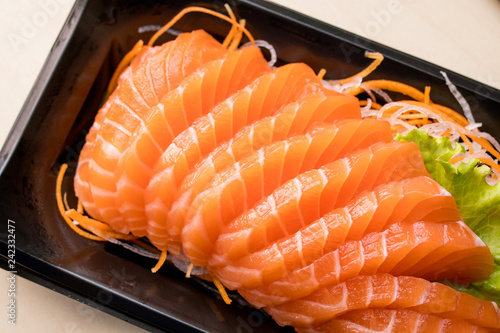 sliced salmon sashimi on black plate