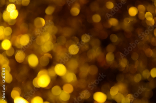 Bokeh. Holiday background. Christmas lights. Glitter. Defocused sparkles. New Year backdrop. Festive wallpaper. Blinks. Carnival. Tinsel. Bokeh retro style photo. Golden. Gold.