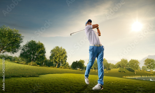 Male golf player on professional golf course. Golfer with golf club taking a shot photo