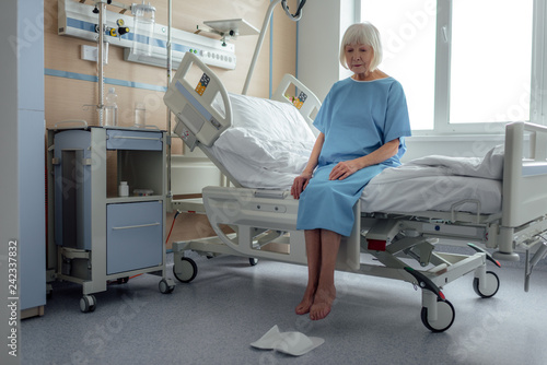 Fotografia upset lonely senior woman sitting on bed in hospital ward