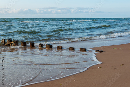 Fototapeta Naklejka Na Ścianę i Meble -  wooden poles from old breakwater leftovers in the sea