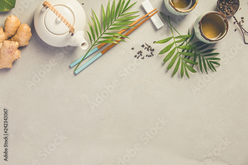 Asian food background, tea and chopsticks on a grey concrete background.