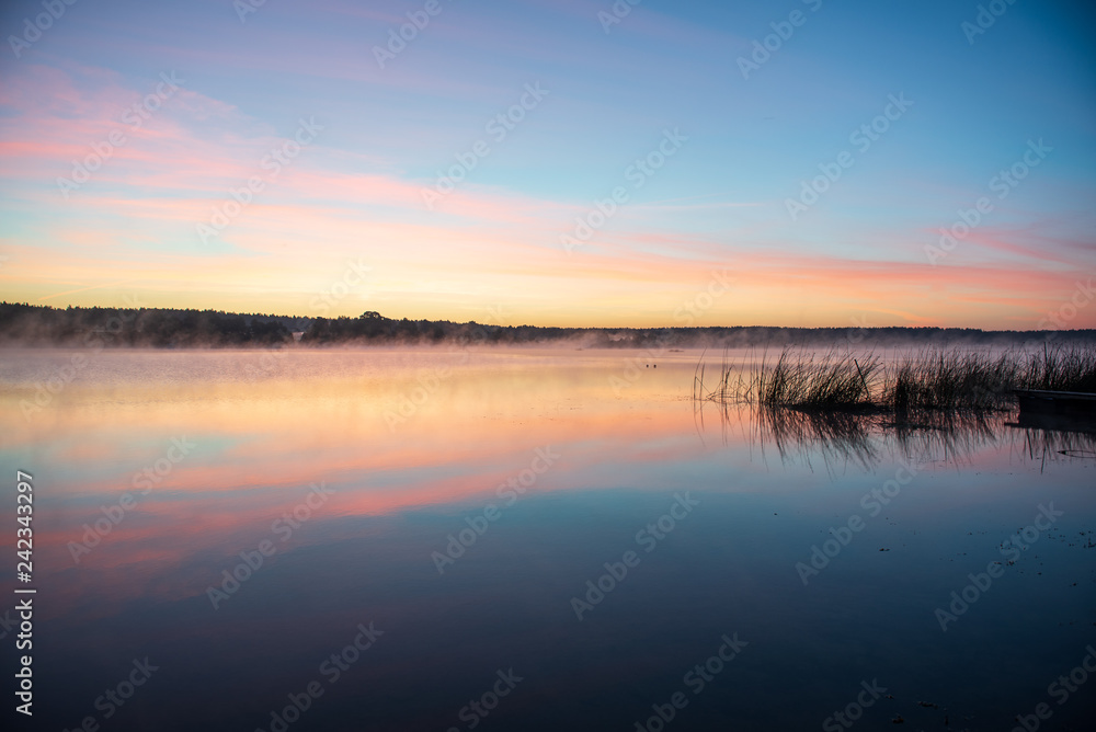 colorful misty sunset on the river in summer