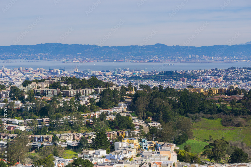 Aerial views of residential areas of San Francisco, San Francisco bay, Oakland and industrial areas in the background, California