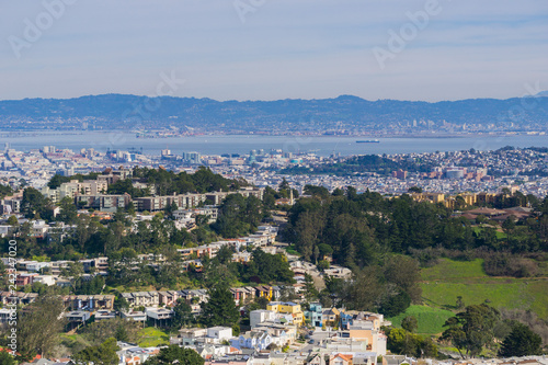 Aerial views of residential areas of San Francisco, San Francisco bay, Oakland and industrial areas in the background, California