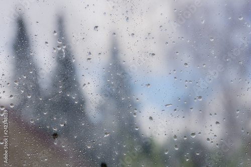 Drops of rain and condensation on the window, blurred trees in the background © Sundry Photography