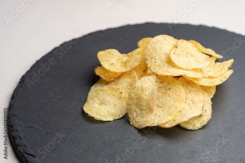 Potato chips on a round slate.