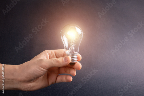 A man's hand holding a burning light bulb. Character birthday party ideas.