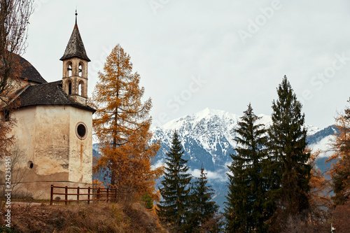 Church and colorful autumn forest with mountains