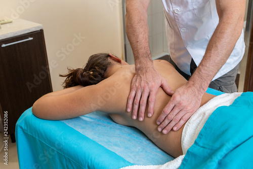 Osteopath therapist, makes the manipulation and massage the patient with an injury.