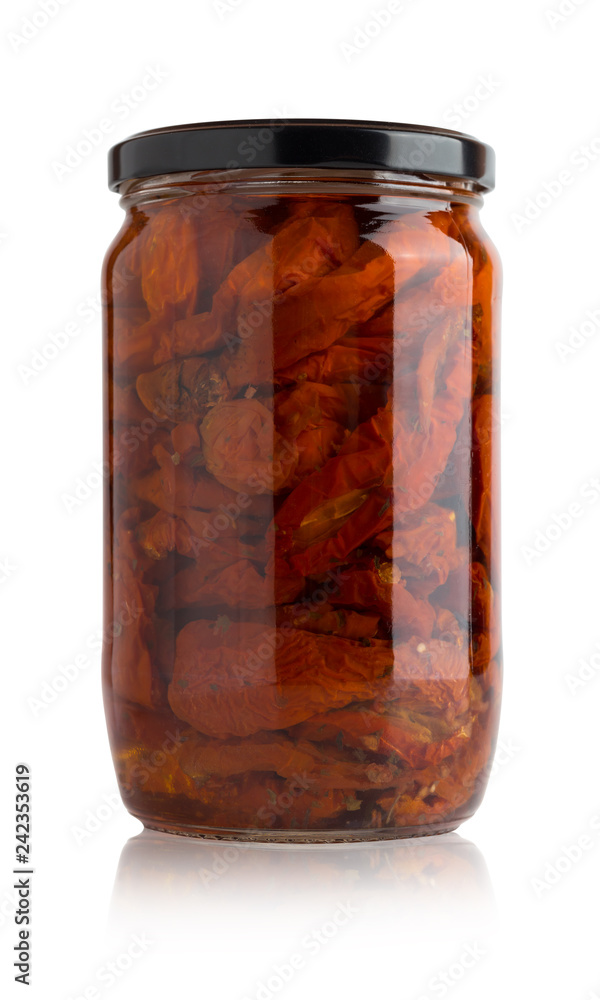 Sun-dried tomatoes in a glass jar. Slices of dried tomatoes in a jar on a white background. Sun-dried tomatoes in a glass jar. Slices of dried tomatoes in a jar on a white background.