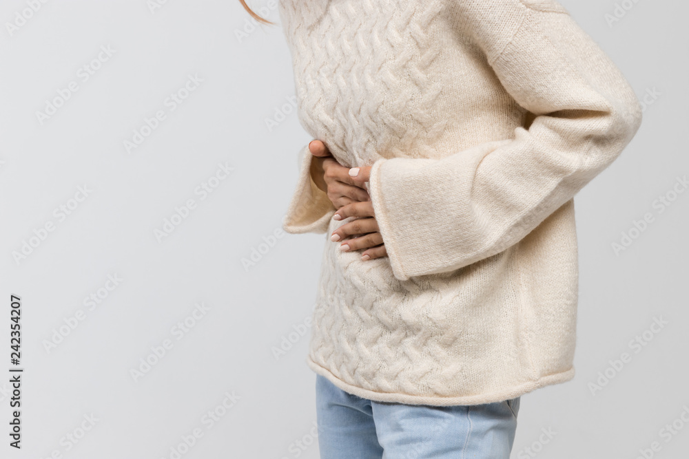 Φωτογραφία Cropped shot of woman in white sweater suffering from abdominal pain, having menstruation pain, feels bad, side view