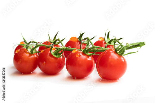 Bunch of fresh red cherry tomatoes with water drops isolated on white