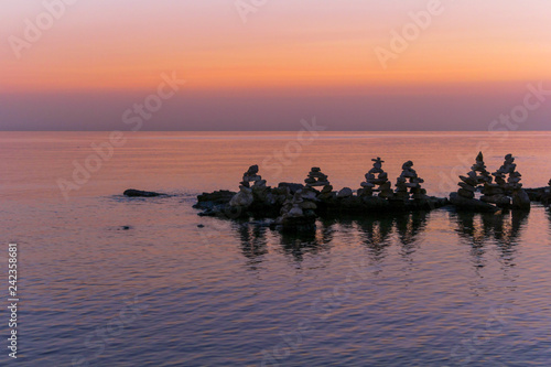 Relaxing pink sea sunset with stones. © Anatoly