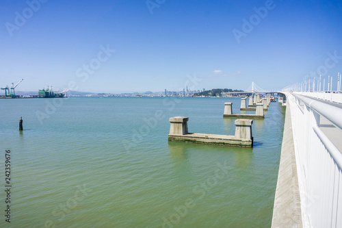 The remaining pylons of the old Oakland - Yerba Buena bay bridge, San Francisco skyline in the background, California photo