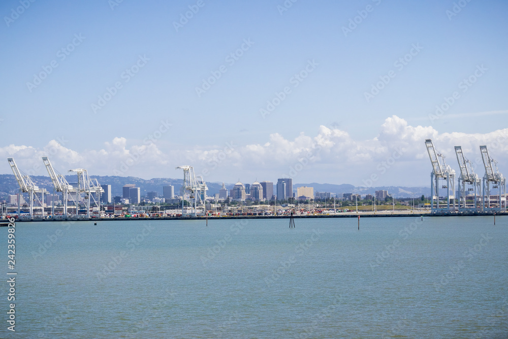 Port of Oakland cranes, Oakland downtown in the background, San Francisco bay area, California