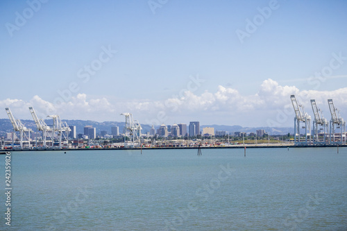 Port of Oakland cranes, Oakland downtown in the background, San Francisco bay area, California © Sundry Photography