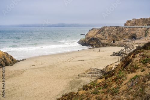 View towards the beach in front of the Sutro Baths ruins on a cloudy day; Point Lobos in the background; Lands End, San Francisco, California