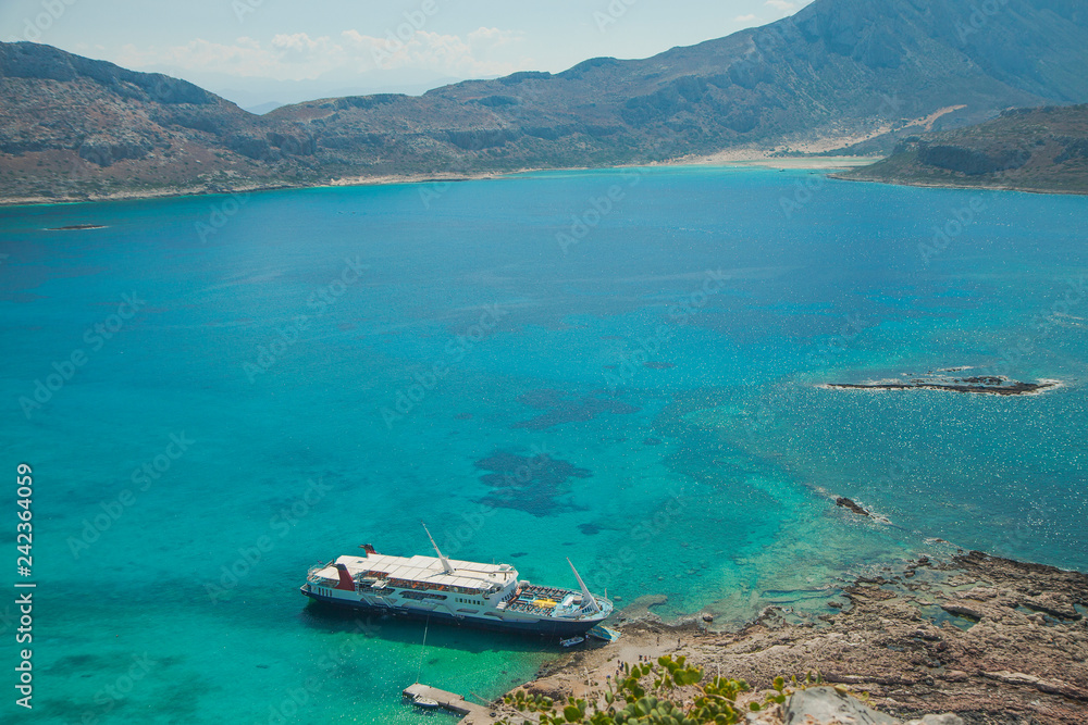 Balos lagoon on Crete island in Greece. Tourist boat in crystal clear water of Balos beach.
