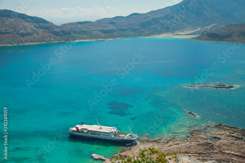 Balos lagoon on Crete island in Greece. Tourist boat in crystal clear water of Balos beach.