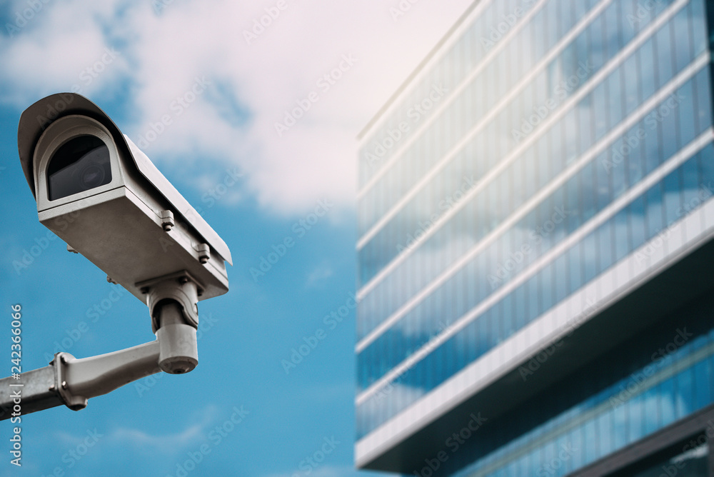 Security camera with a glass building on the background Security camera with a glass building on the background