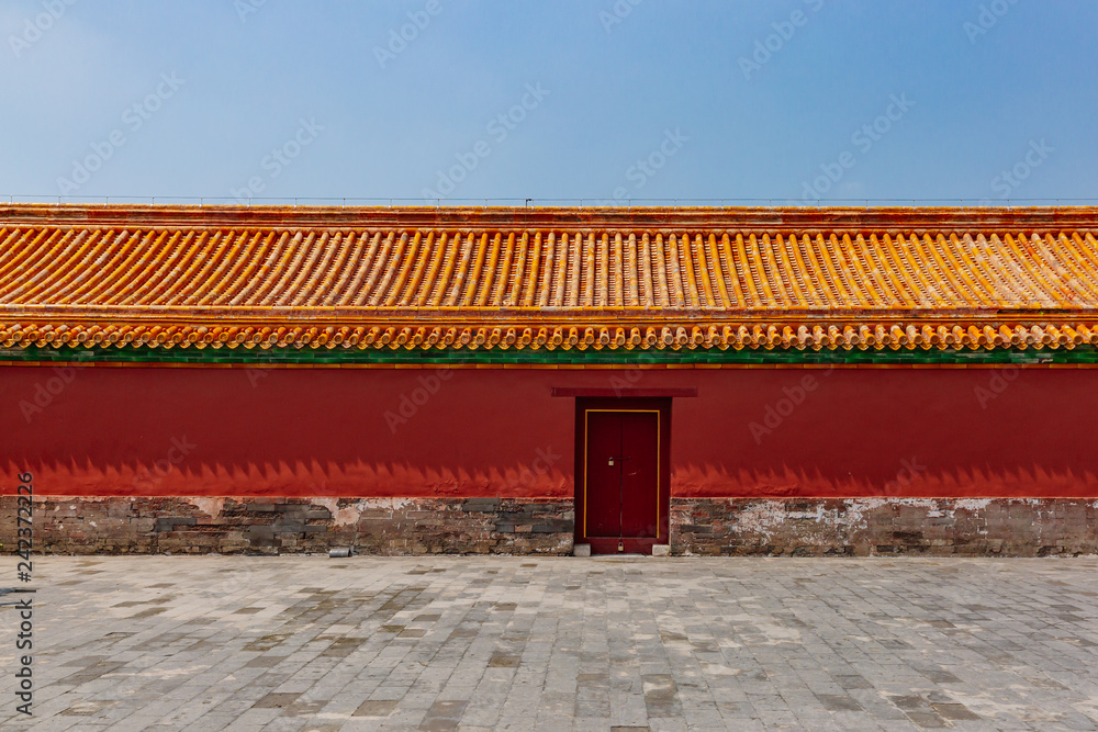Traditional Chinese red wall and yellow roof tiles with closed door, in Forbidden City, in Beijing, China