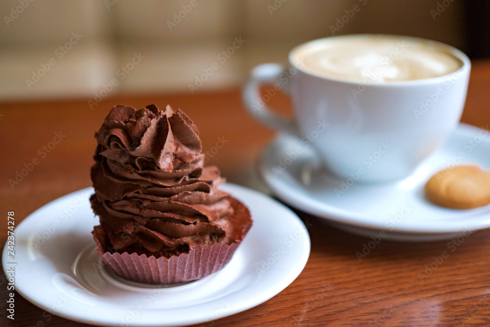 Chocolate cake with a cup of coffee on the table in a coffee shop. Sweet snack at lunch. Sweets Chocolate cake with a cup of coffee on the table in a coffee shop. Sweet snack at lunch. Sweets