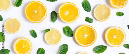 Photo of orange and lemon slices with mint on a white background. Background for the design of banners, websites, blogs, information block. Frame for banner with orange and lemon