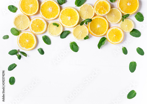 Photo of orange and lemon slices with mint on a white background. Background for the design of banners, websites, blogs, information block. Frame for banner with orange and lemon