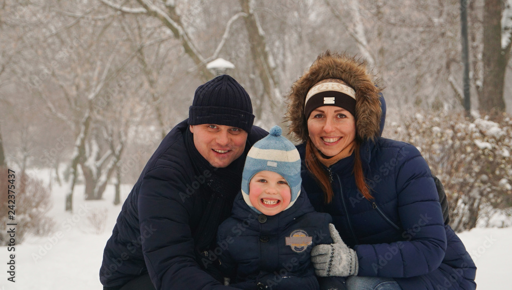 Family portrait of the father, mother and little boys in the winter park