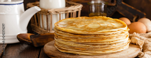Homemade thin crepes with honey, pancakes on wooden rustic background