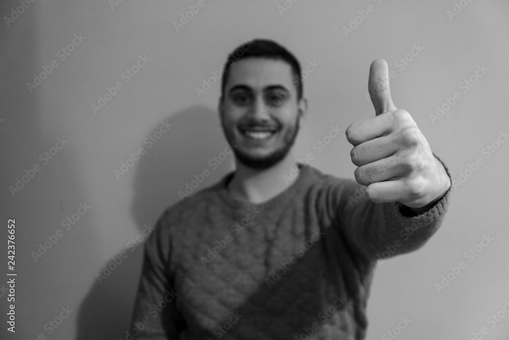 Portrait of a smiling young boy while he thumbs up with his hand. Portrait of a smiling young boy while he thumbs up with his hand.