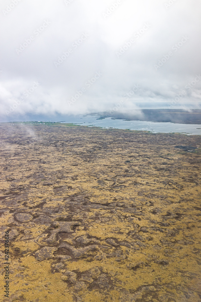 Keflavik, Iceland landscape view from airplane flying above the country, coastline with high angle aerial brown volcanic land