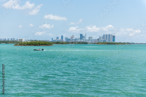 Boat in Bal Harbour, Miami Florida with light green turquoise ocean Biscayne Bay Intracoastal water and cityscape skyline of Sunny Isles Beach