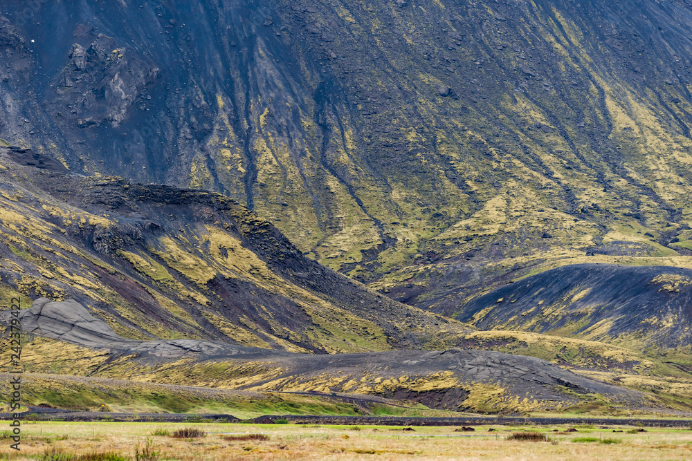 Iceland barren landscape view of rocky mountain cliff foothill during day on south southern ring road or golden circle Iceland barren landscape view of rocky mountain cliff foothill during day on south southern ring road or golden circle