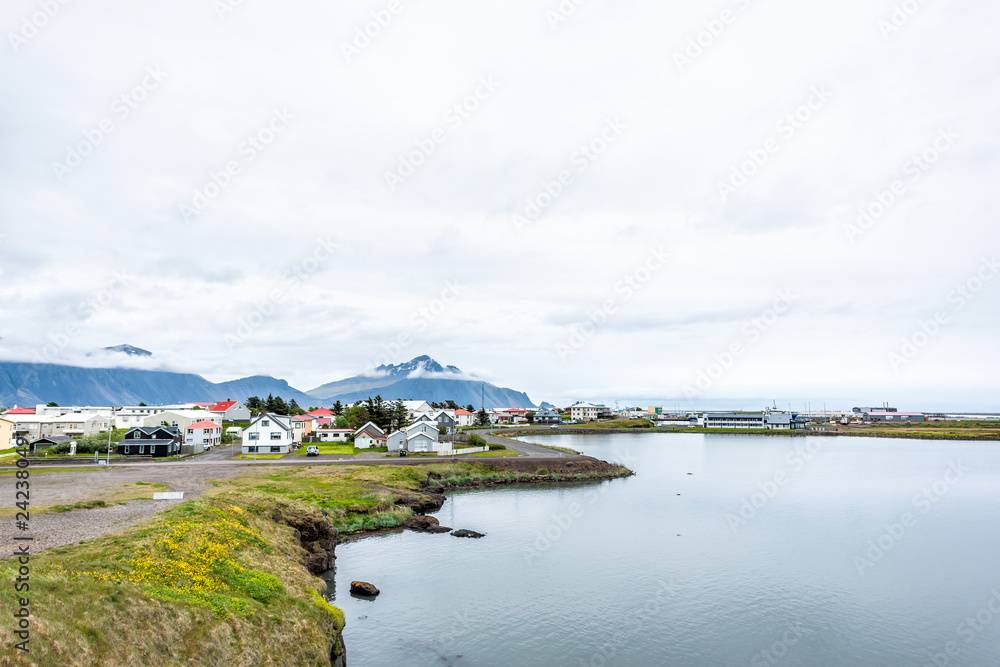 Landscape cityscape view of peaceful picturesque village by tranquil fjord water river and mountains in small fishing town called Hofn in Iceland cityscape